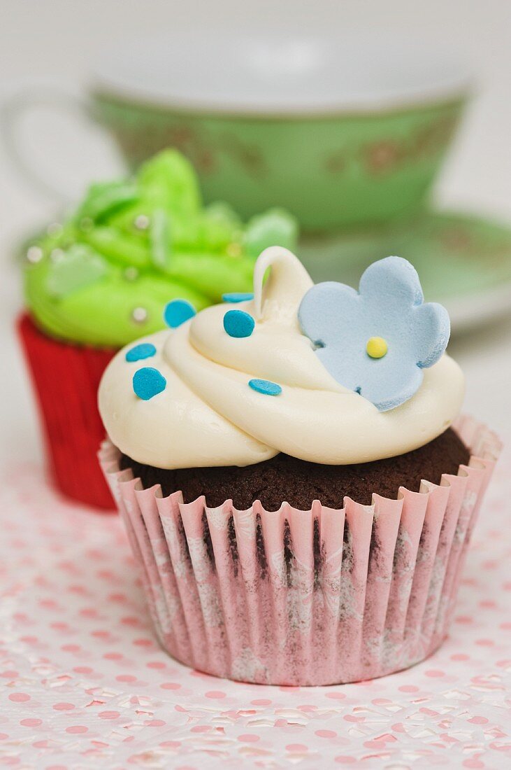 Cupcakes mit Zuckerblumen auf Tortenpapier