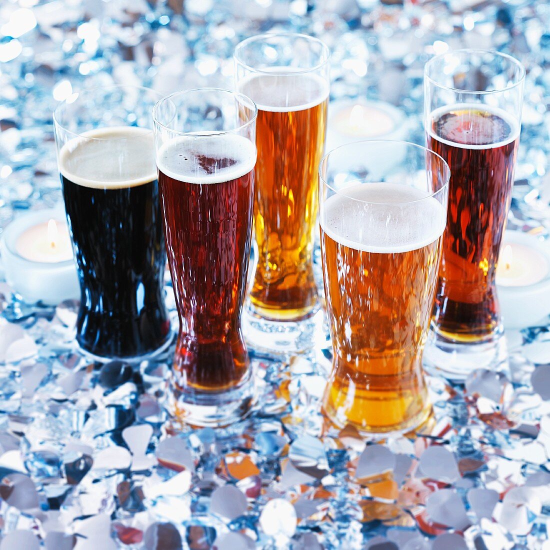 Various glasses of beer with tealights