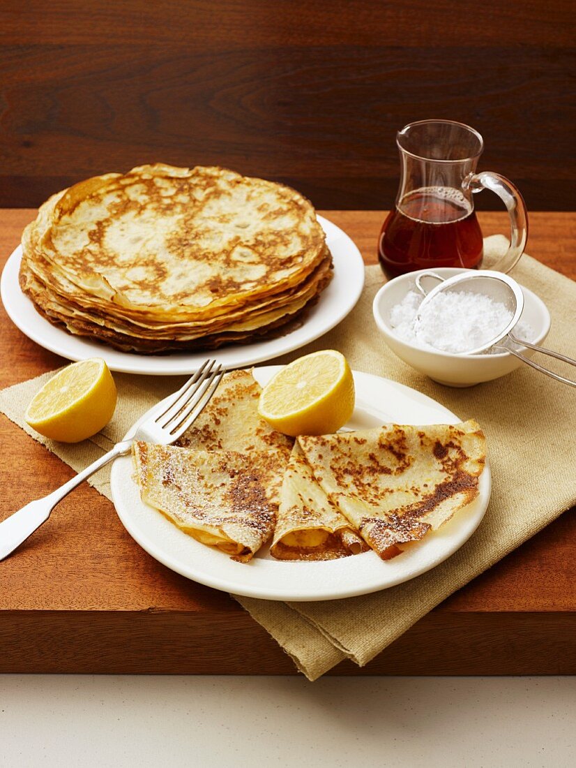Crepes with lemon, icing sugar and maple syrup