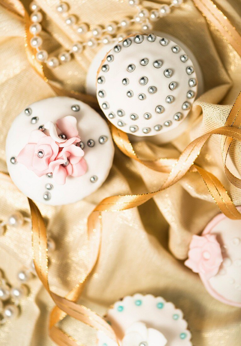 Festive cupcakes decorated with silver pearls and sugar flowers