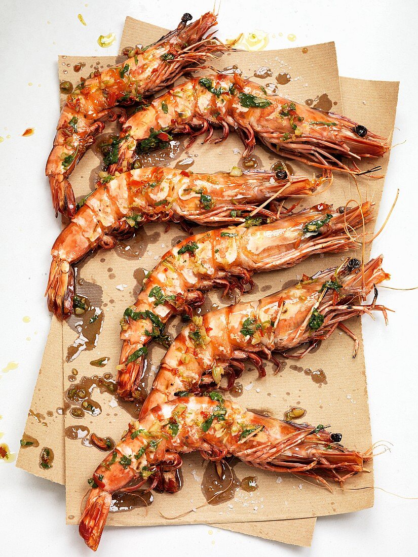 King prawns with herbs on brown paper