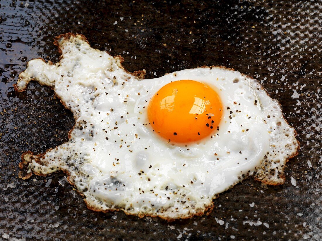 A fried egg with ground black pepper