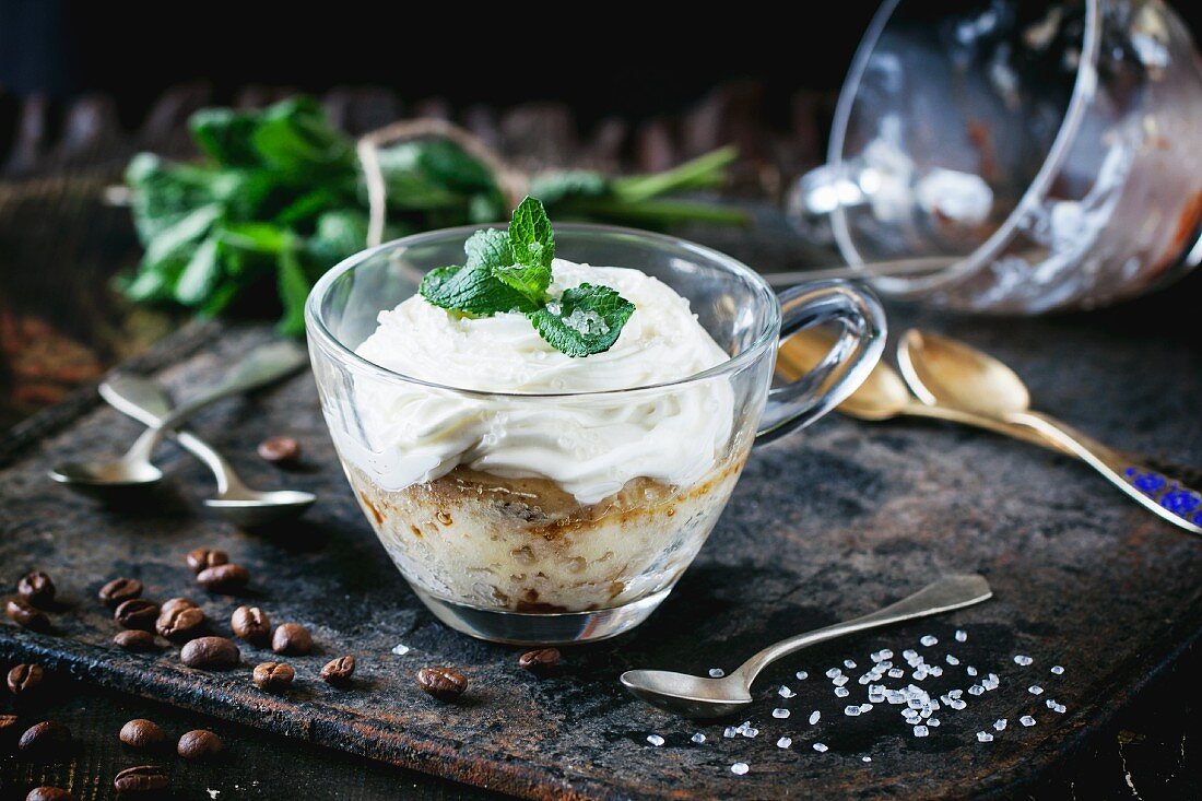 Sponge cake with cream, coffee and fresh mint in a glass cup