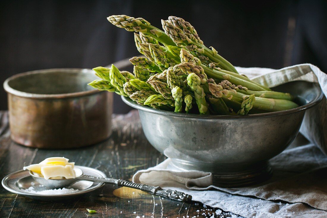 Green asparagus in a vintage bowl served with salt and butter