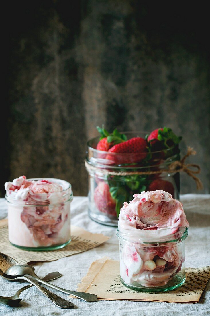 Strawberry ice cream in glass jars and fresh strawberries