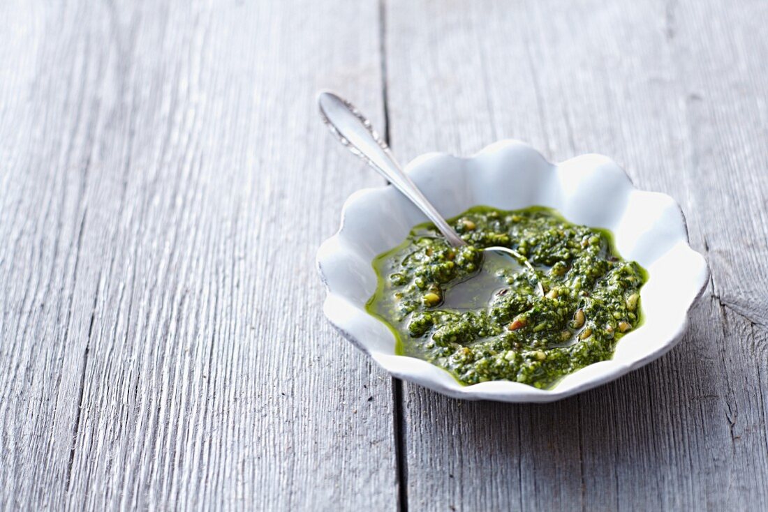 A bowl of pesto with a spoon