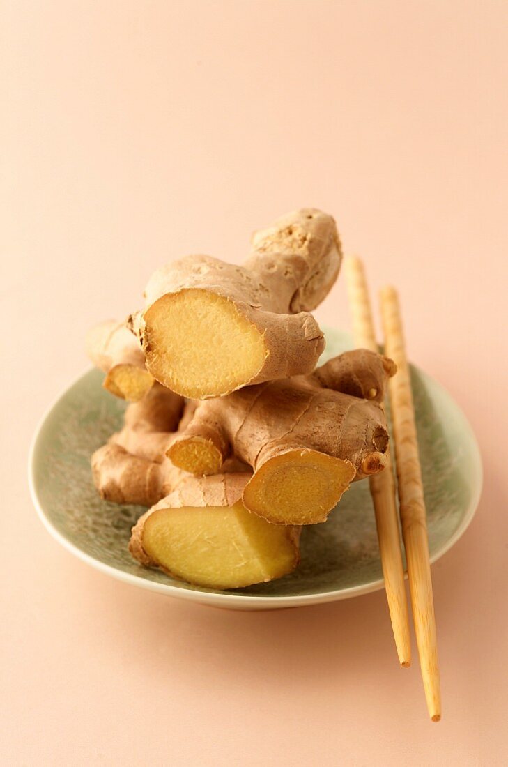 A bowl of fresh ginger with chopsticks