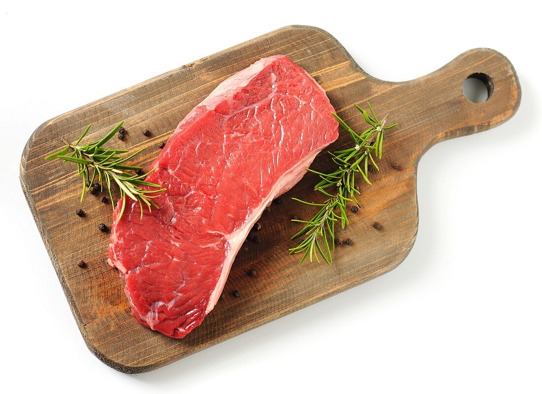 A raw rump steak on a chopping board