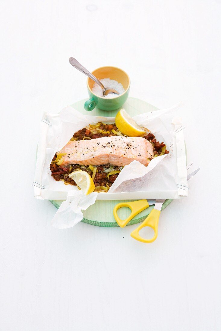 Steamed salmon on a lentil medley in baking paper