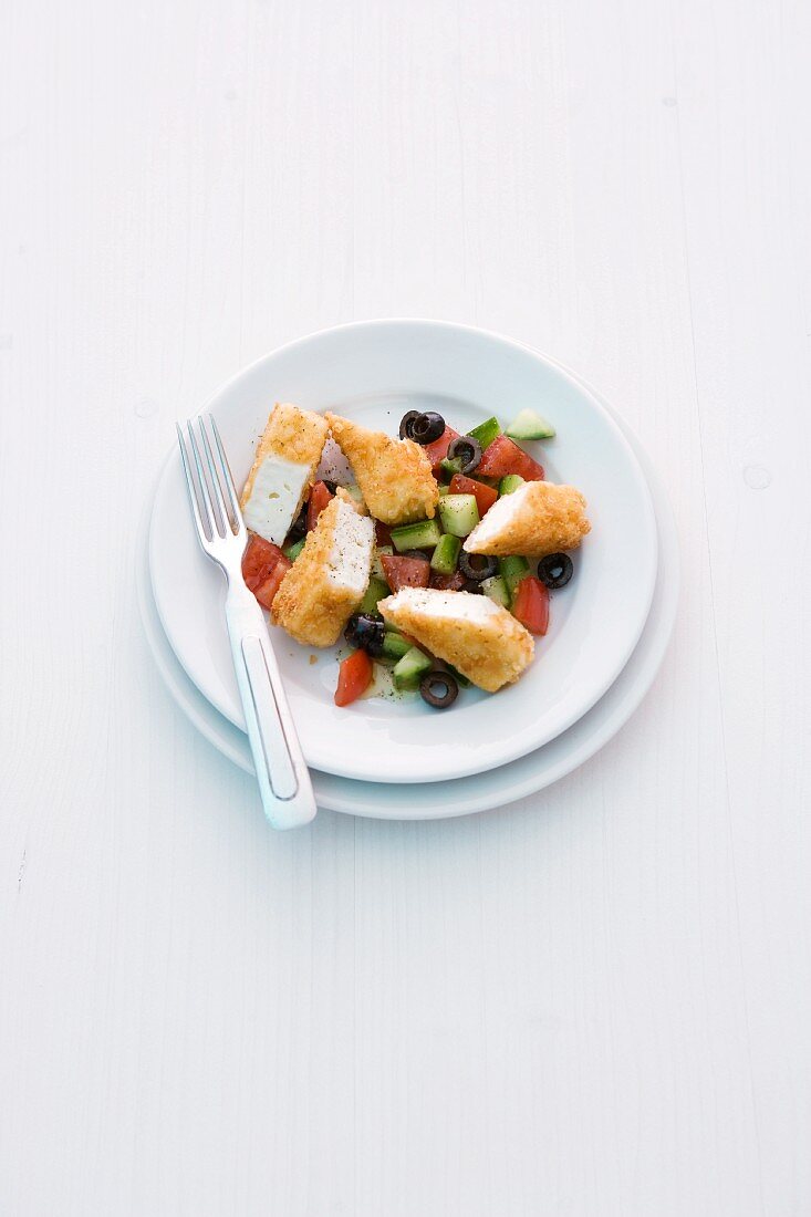 Panierte Feta-Sticks auf Gurken-Tomaten-Salat