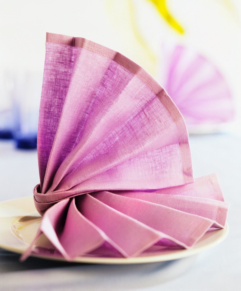 A decoratively folded purple napkin on a plate