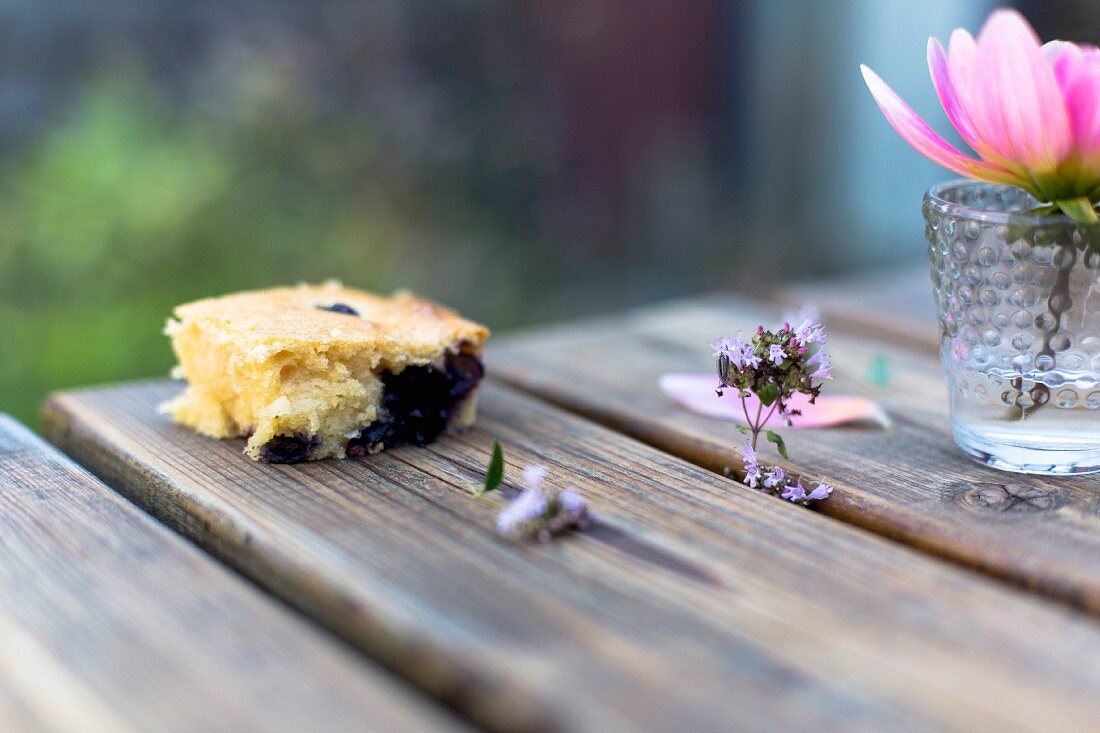 A slice of berry cake on a wooden table