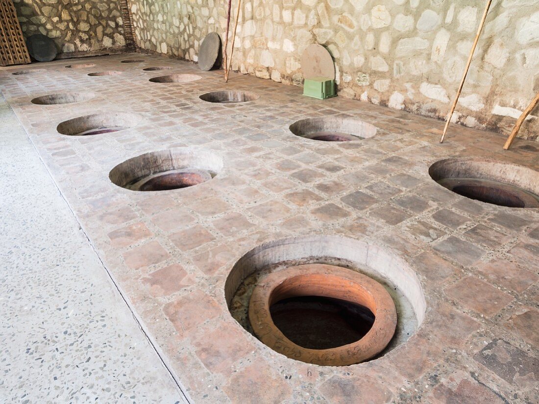 Kvevri (buried wine amphorae) in a wine cellar in the Kakheti wine region, Georgia, Caucasus