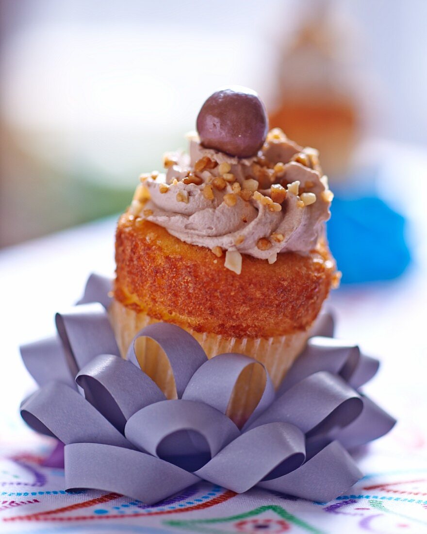 A nut cupcake on a decoratively folded ribbon
