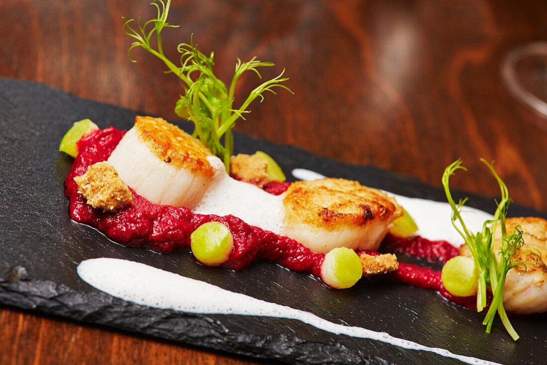 Scallops on beetroot cream with apple pearls and nut crumble