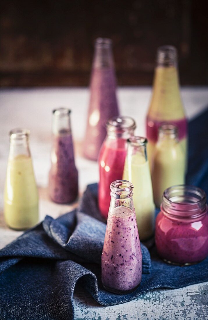 Various fruit smoothies (raspberry, blueberry and apple) in bottles