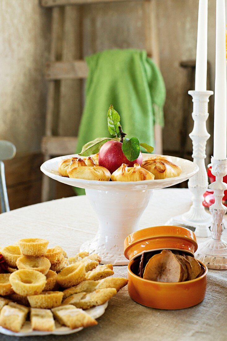 Gedeckter Tisch mit Apfelchips, Apfelmuffins, Apfeltaschen und Apfelstrudel