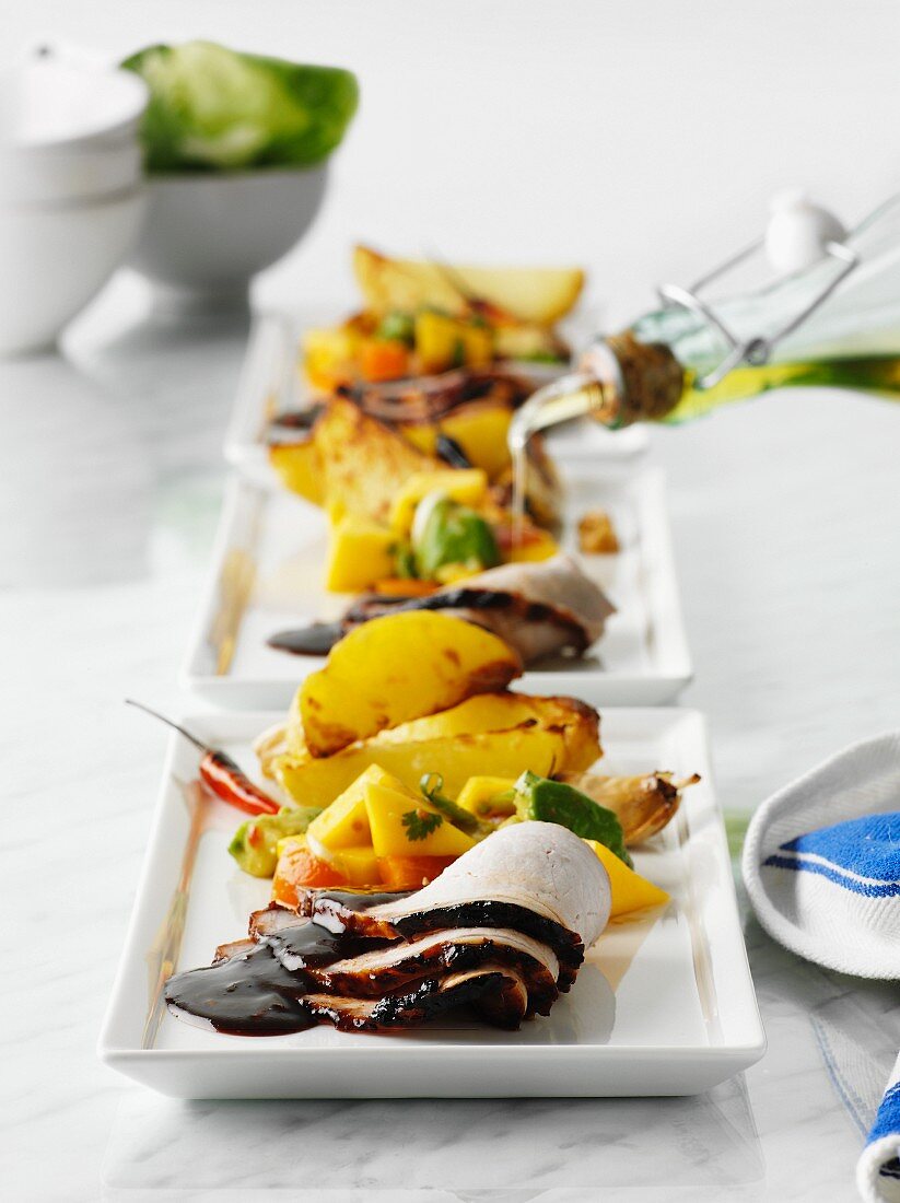 Glasierte Geflügelbrust in Scheiben mit Kartoffelspalten, Mango & Papaya