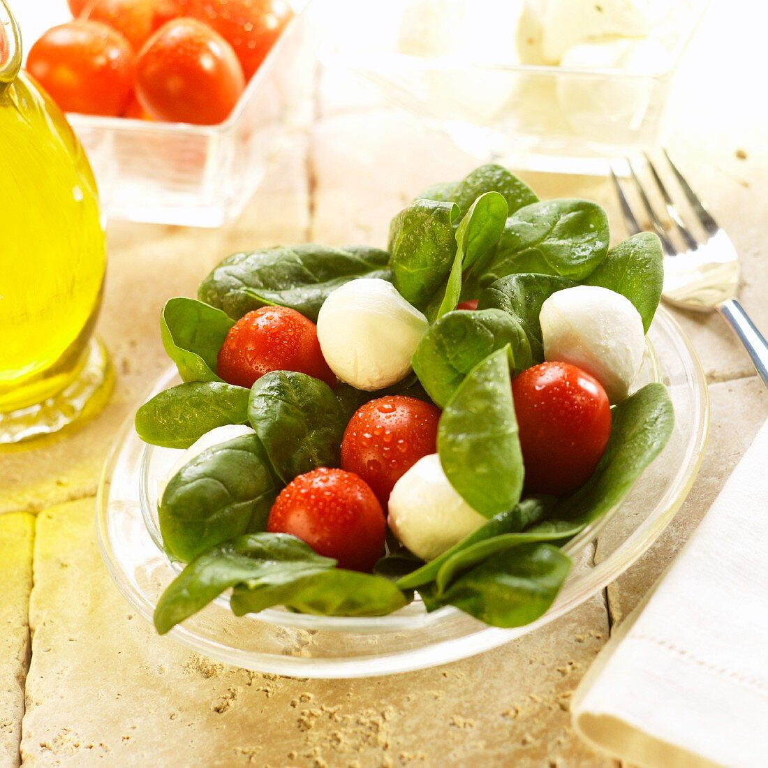 Spinatsalat mit Mozzarellakugeln und Tomaten, Olivenöl