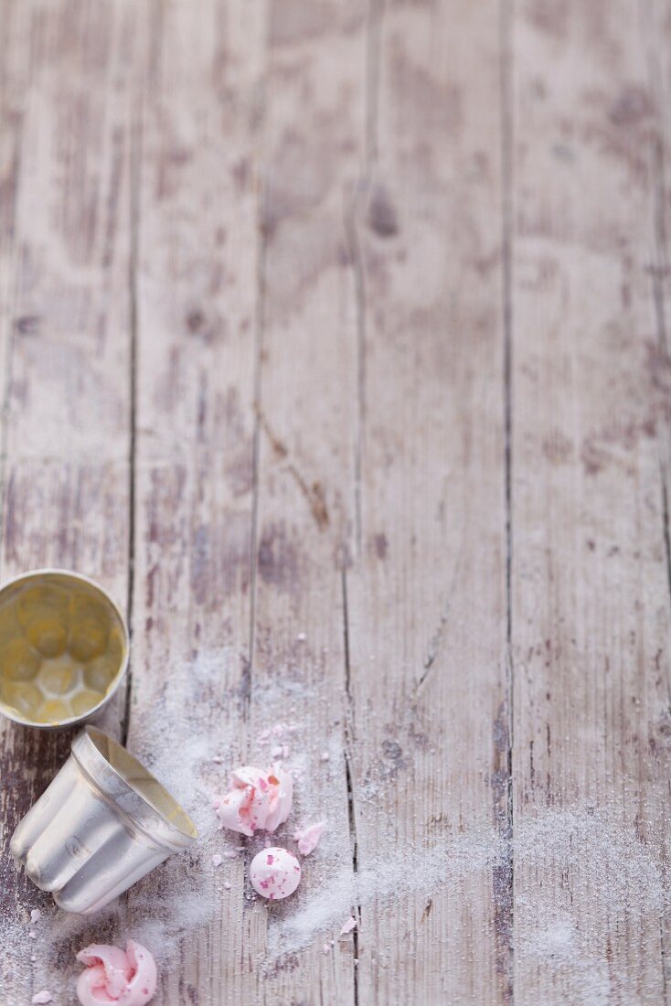 Baking tins and meringues on a rustic wooden table