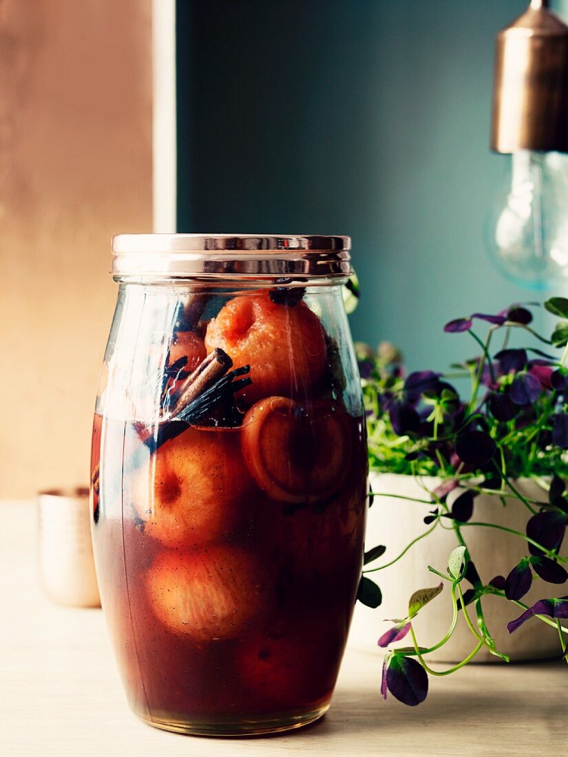 Marinated plums with anise, vanilla, cinnamon and rum in a preserving jar