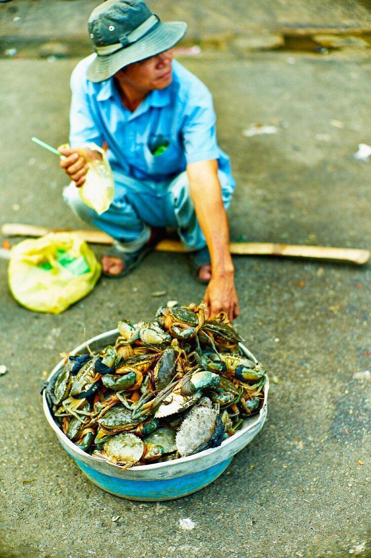 Mann verkauft Krustentiere auf einem Markt in Saigon (Vietnam)