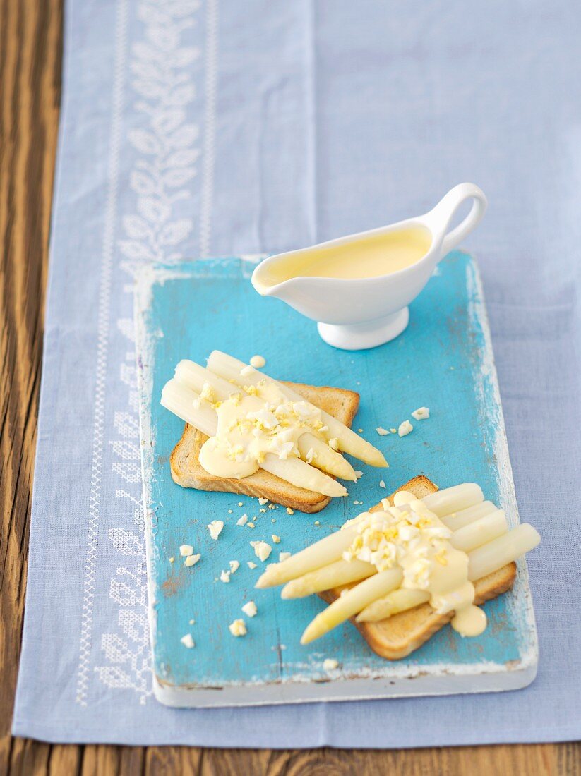 Toast topped with white asparagus and Hollandaise sauce