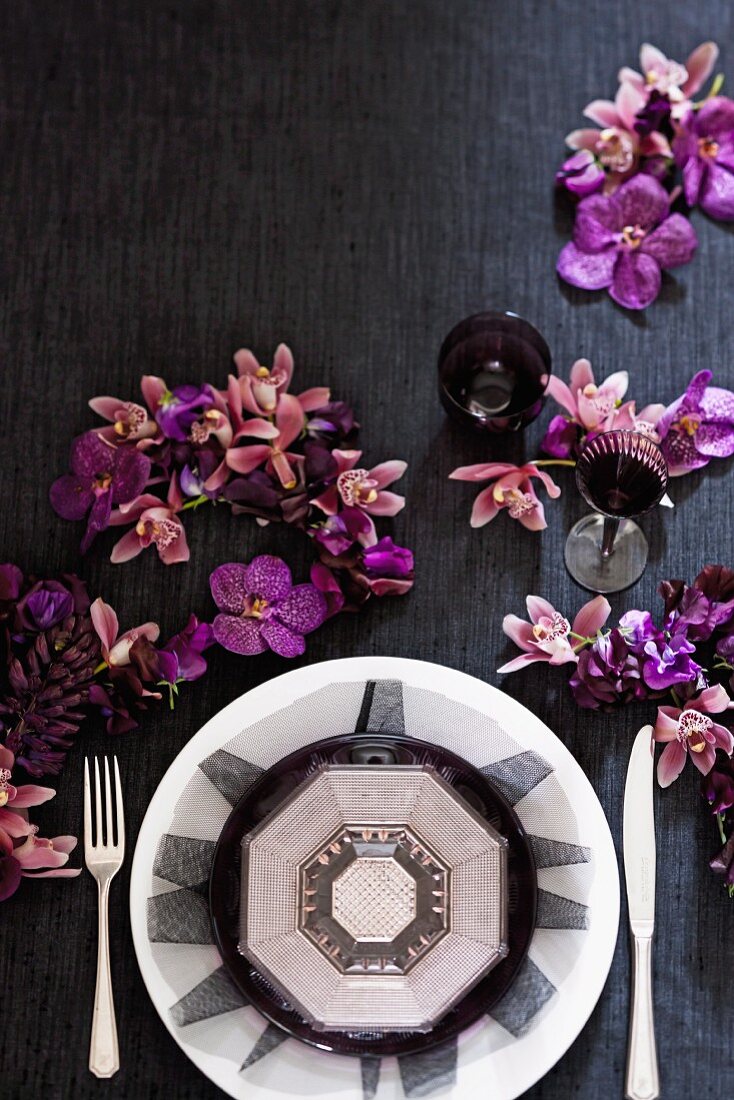 Hintergrund für dekadente Gerichte (Gedeck, lila Orchideen, Gläser)