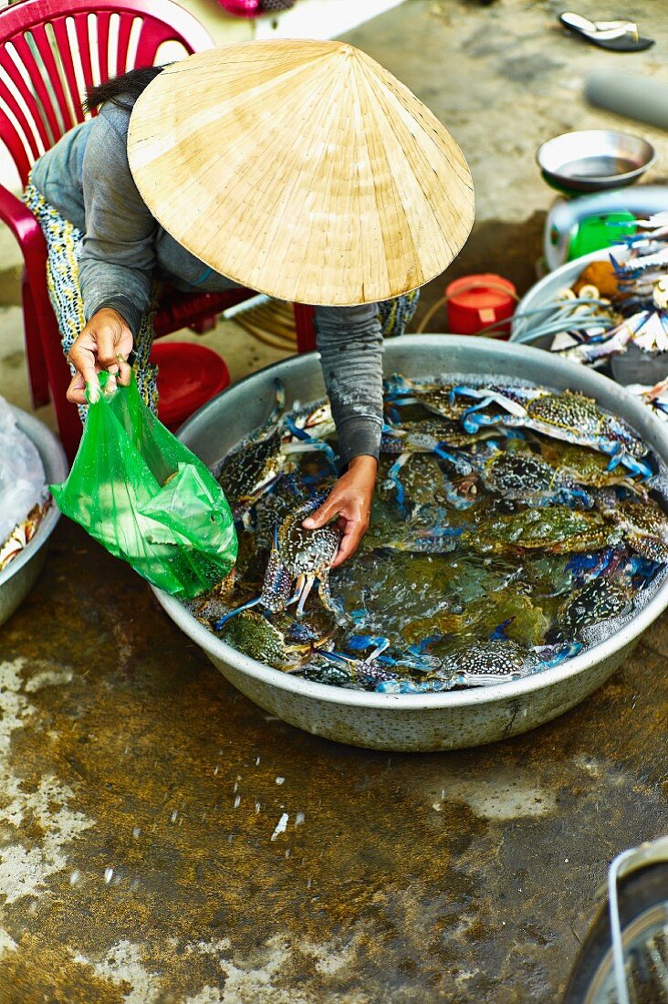 Frau verkauft frische Blaukrabben auf einem Markt in Saigon (Vietnam)