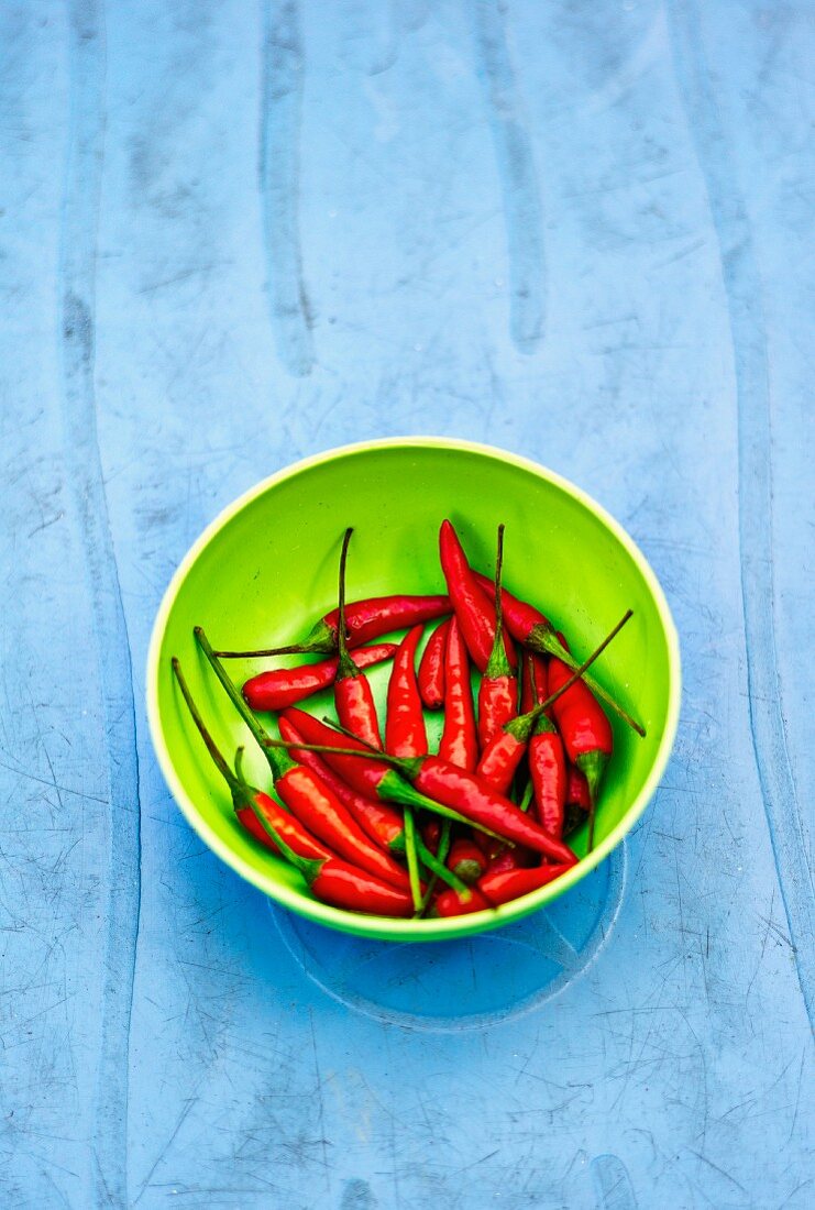 Fresh red chilli peppers in a green bowl