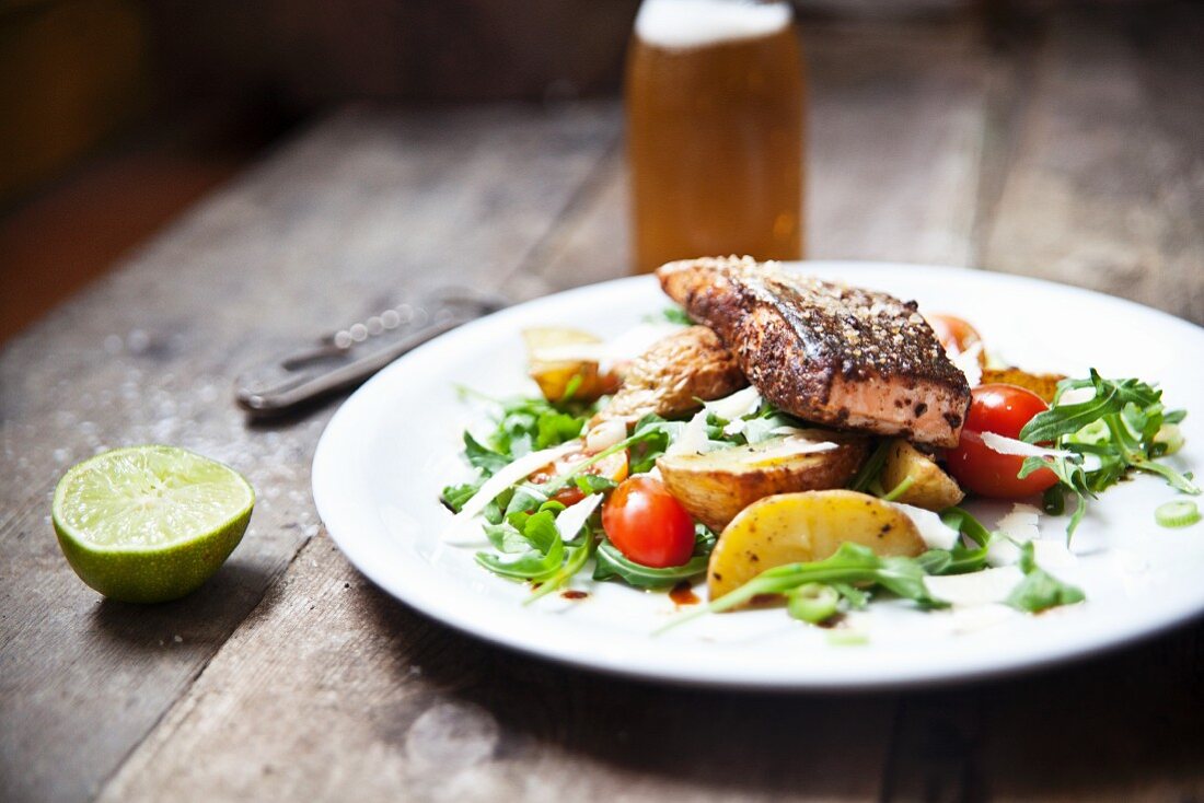 Gegrilltes Cajun Lachssteak auf Kartoffelspalten und Rucola-Tomatensalat mit Parmesan