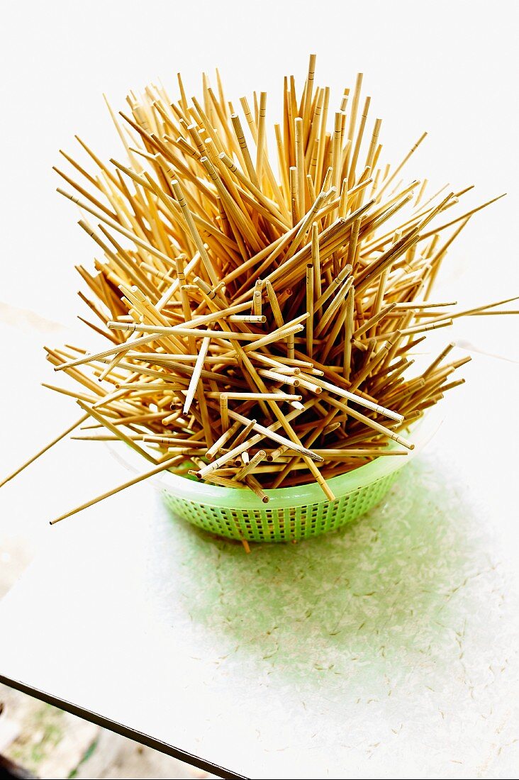 Wooden toothpicks in a plastic sieve