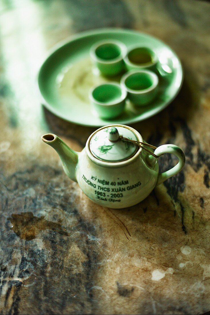 Hellgrünes asiatisches Teeservice auf alter Holzfläche