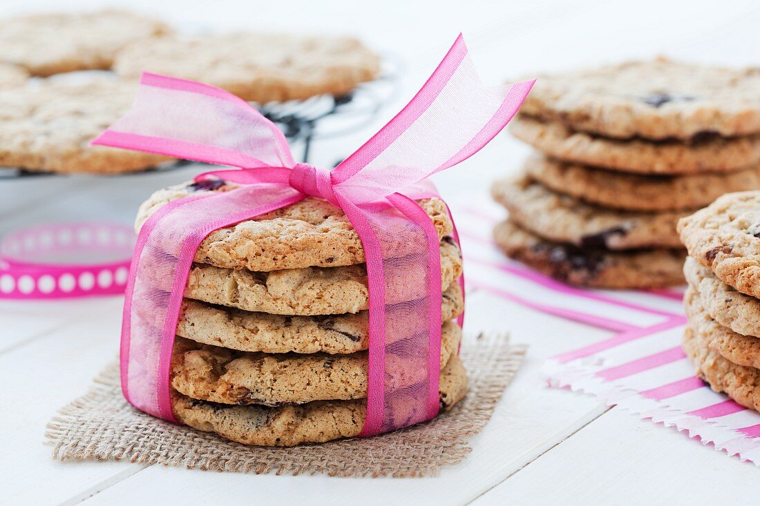 A stack of chocolate chip cookies tied with a pink ribbon