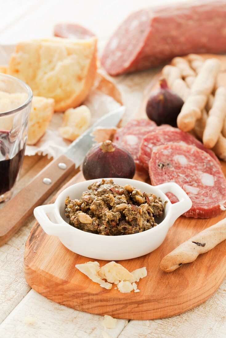 A platter of cheese and cured meats with cocoa pesto, figs and grissini