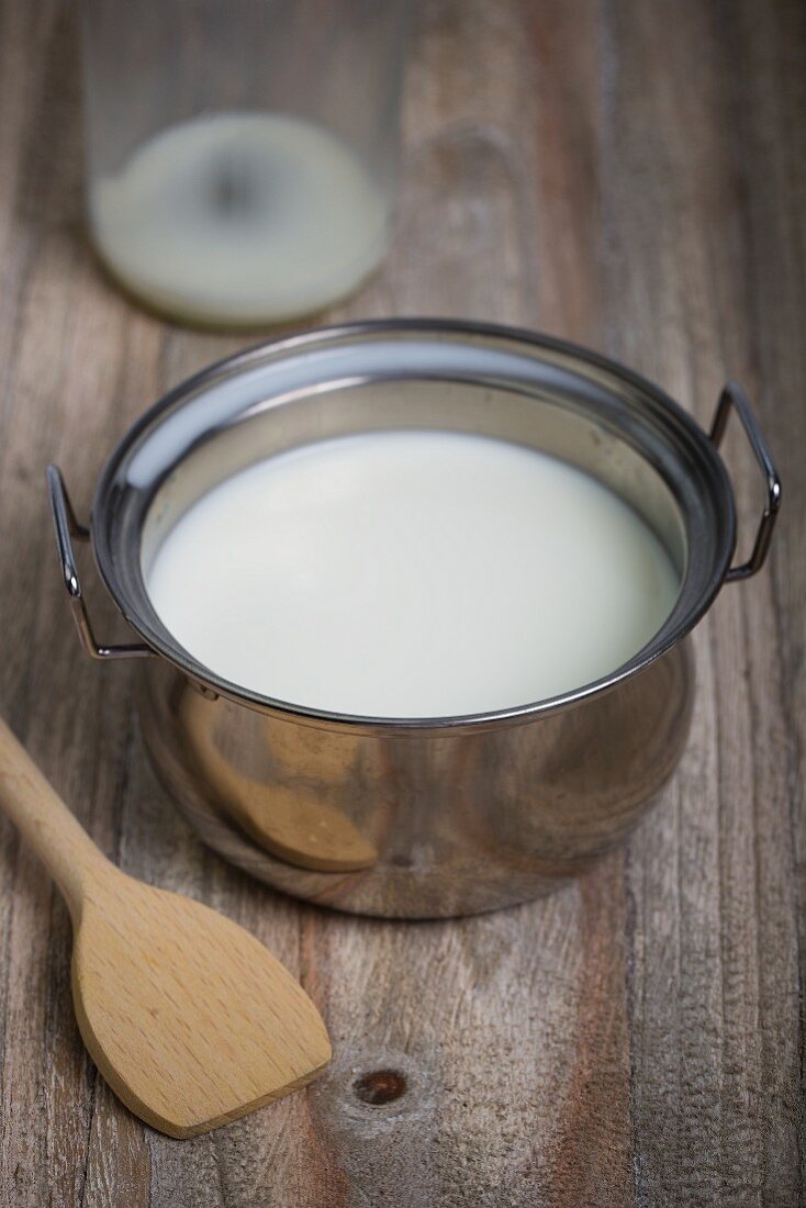 Milk in a pan on a wooden surface