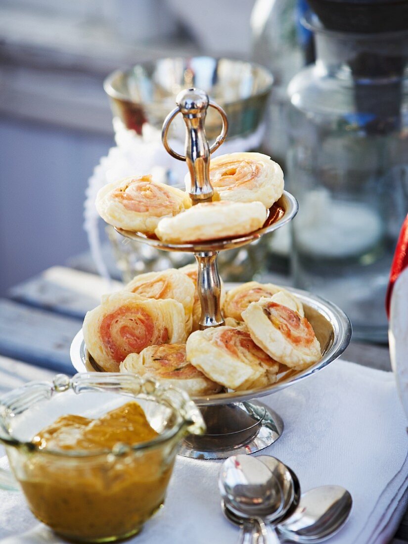 Salmon and puff pastry roulade on a cake stand served with mustard sauce (Christmas)