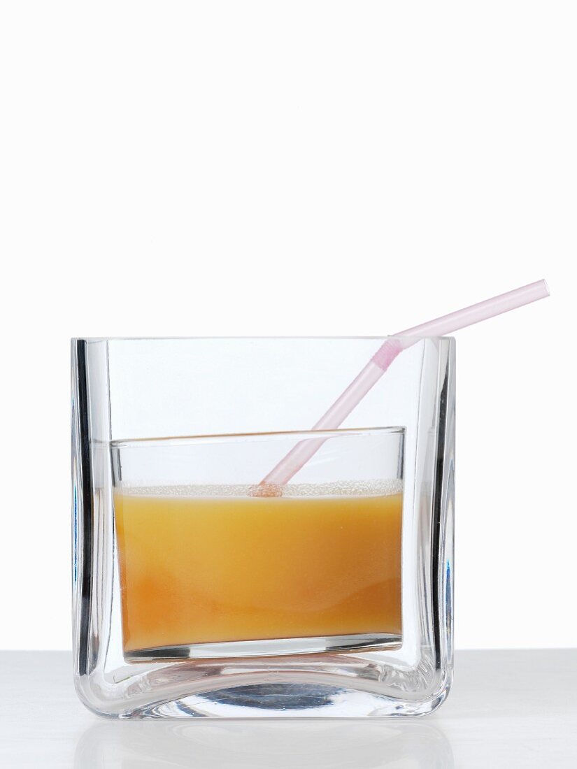 Apricot juice with a straw in a thick glass