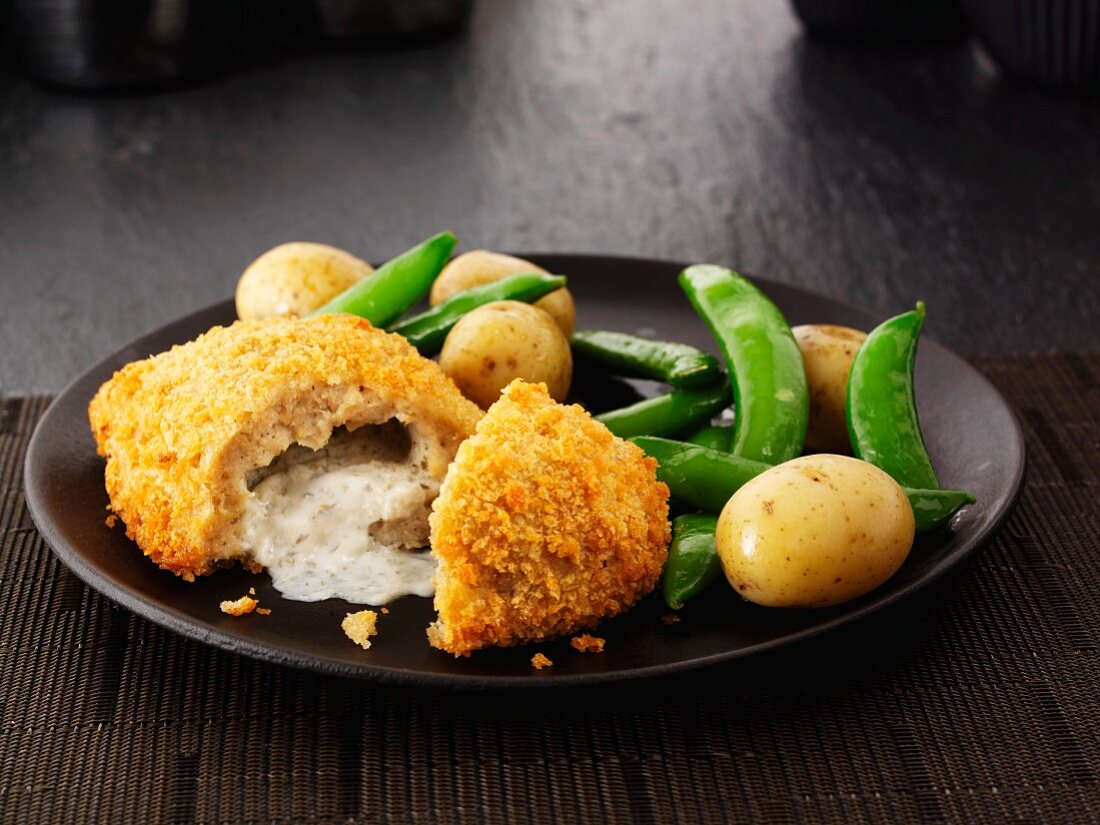 Chicken Kiev with mange tout and potatoes