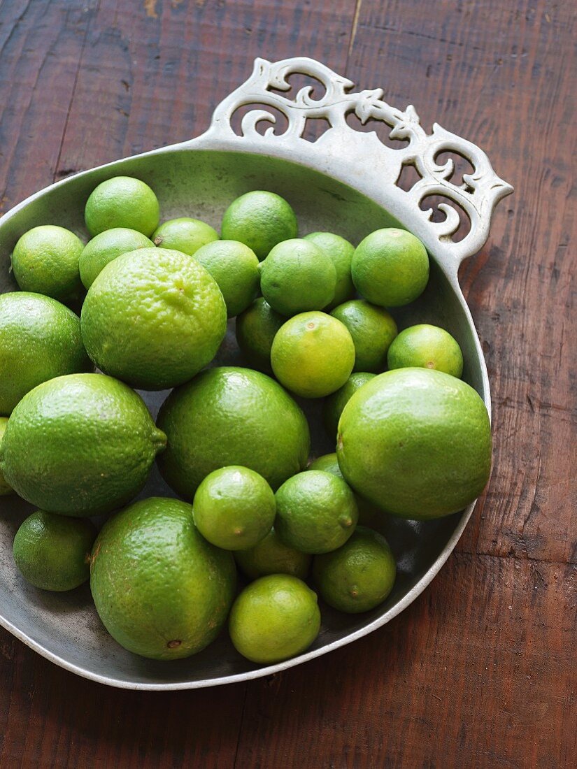 Large and small limes in a pewter bowl