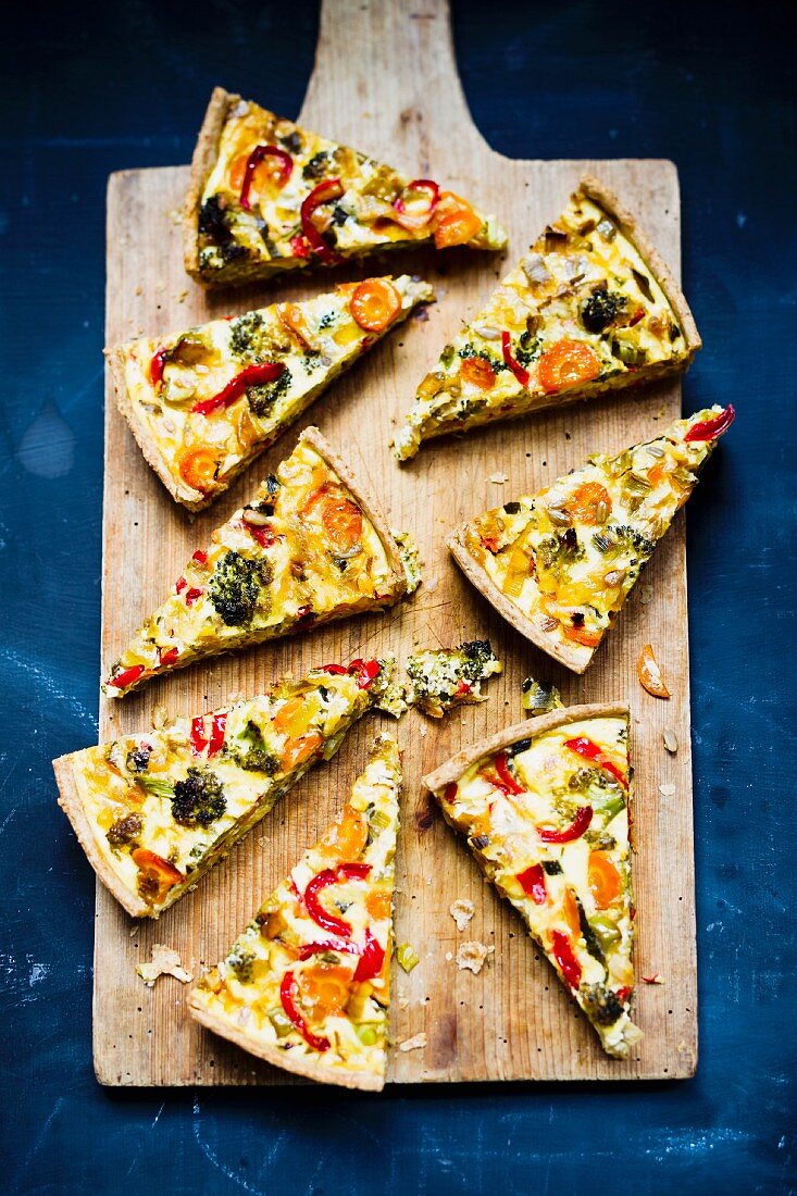 Vegetable quiche, sliced, on a chopping board