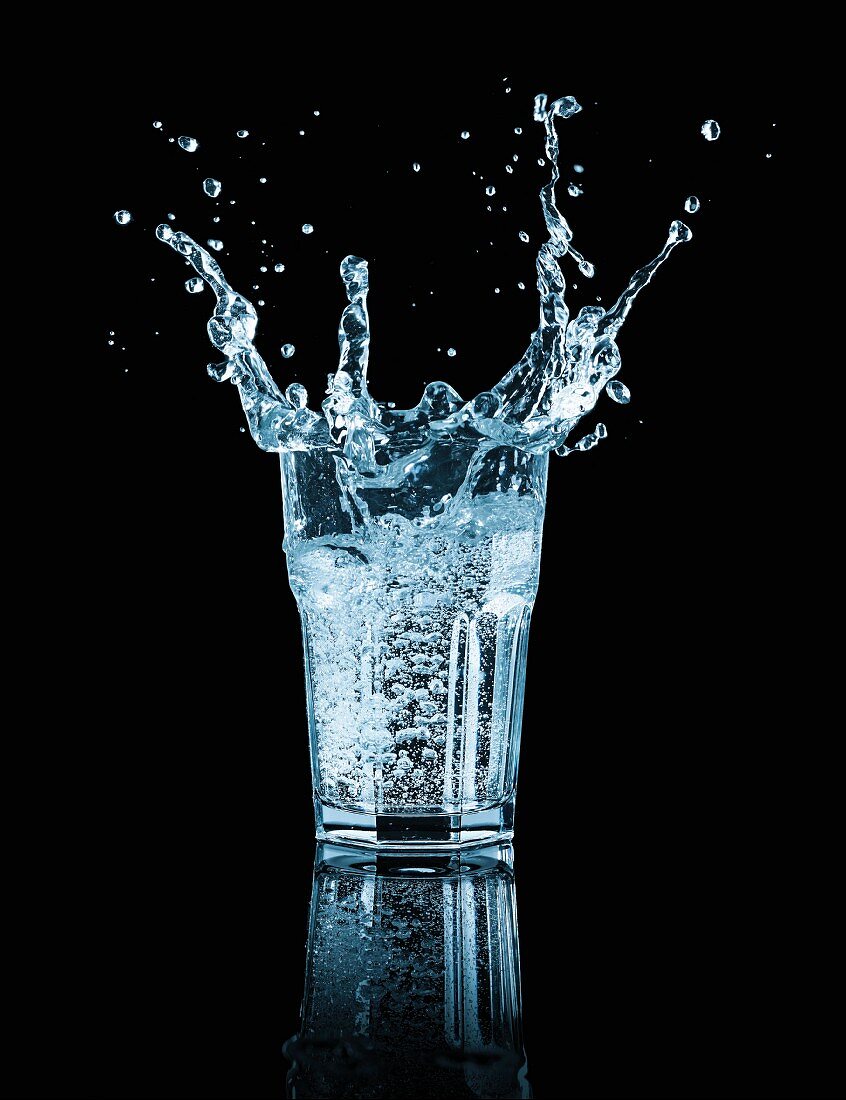 A splashing glass water against a black background