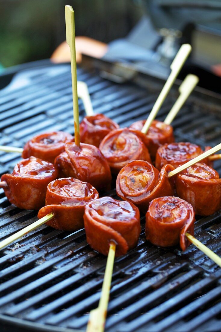 Sausage snails on skewers on a barbecue