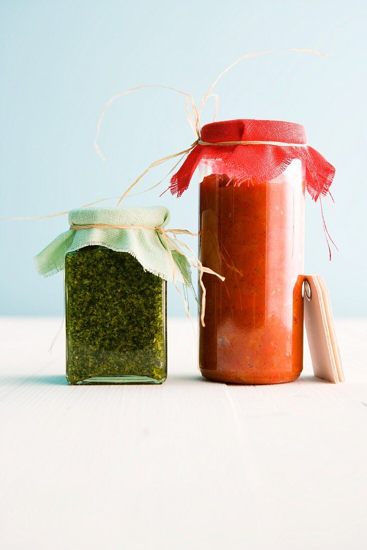 Sweet and spicy pepper and tomato sugo next to basil and lemon pesto