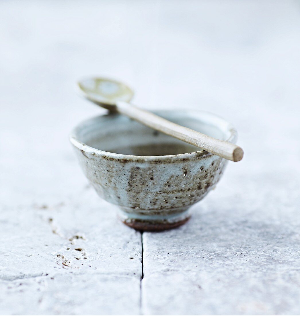 Traditionelle japanische Keramikschale mit Tee und Löffel
