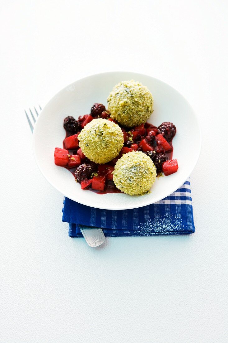 Sweet potato dumplings with pistachio crumbs on an apple and berry compote