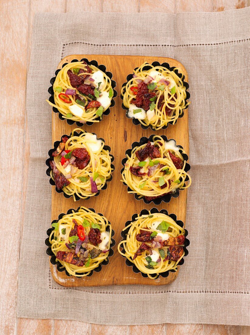 Gratinated spaghetti nests with bacon and dried tomatoes