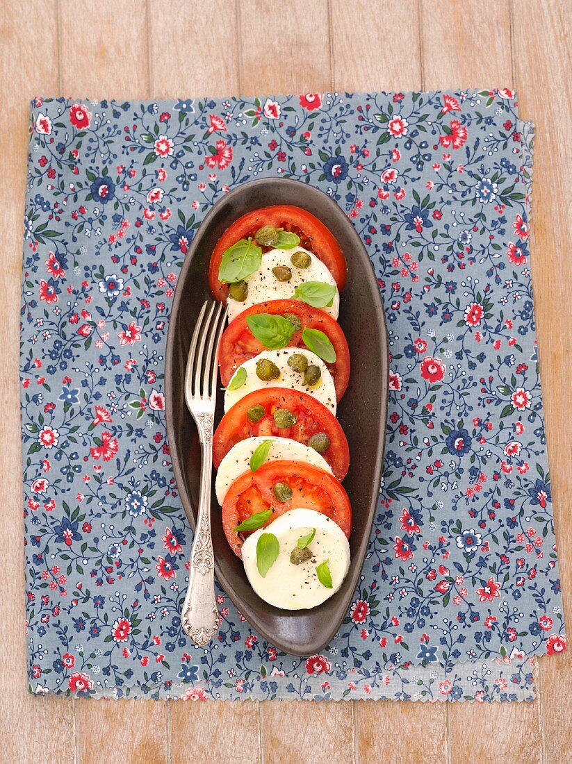 Tomatoes with mozzarella, capers and basil