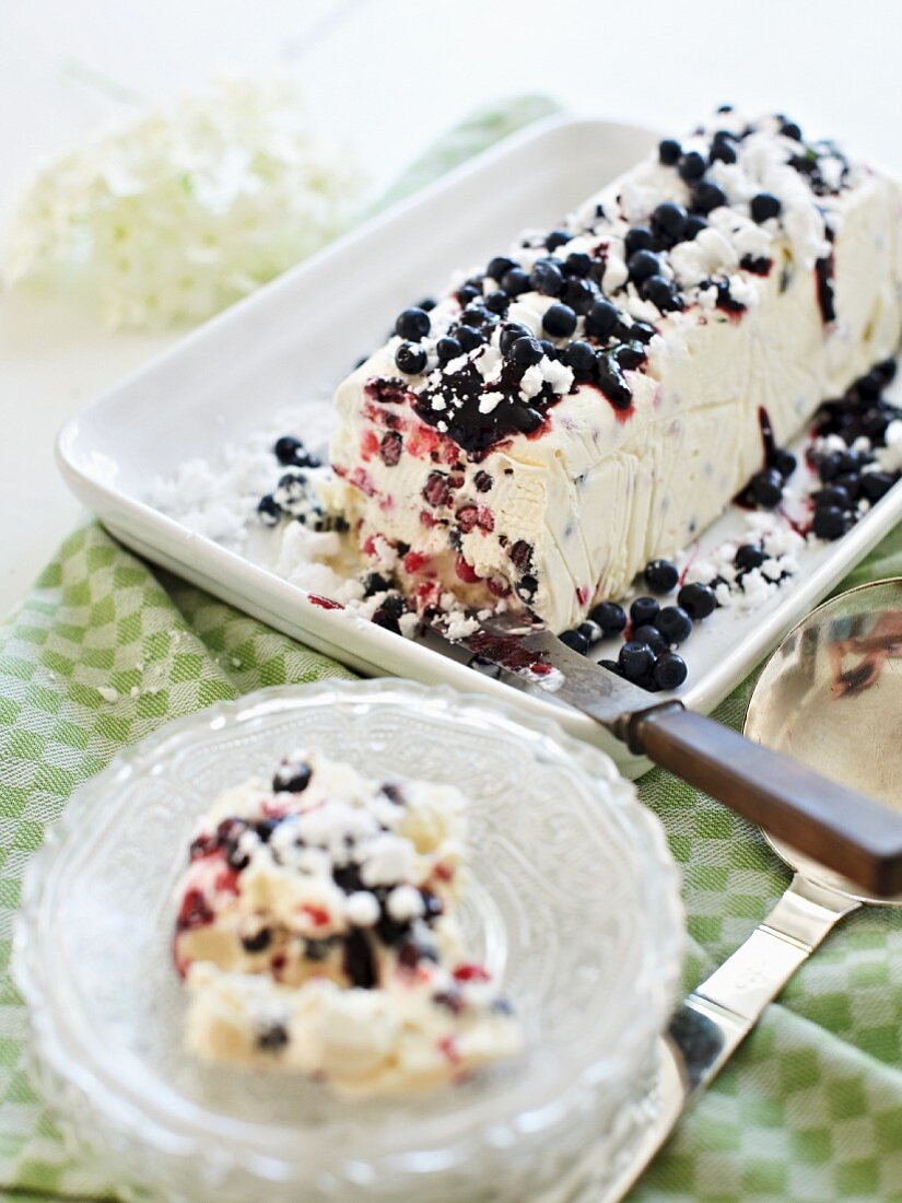 An ice cream cake with blueberries and meringues
