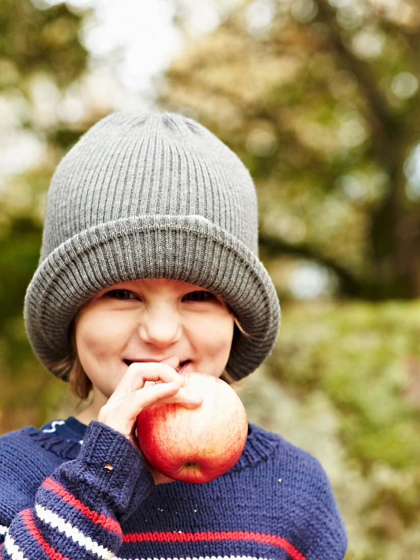 Mädchen hält Apfel beim Herbstpicknick